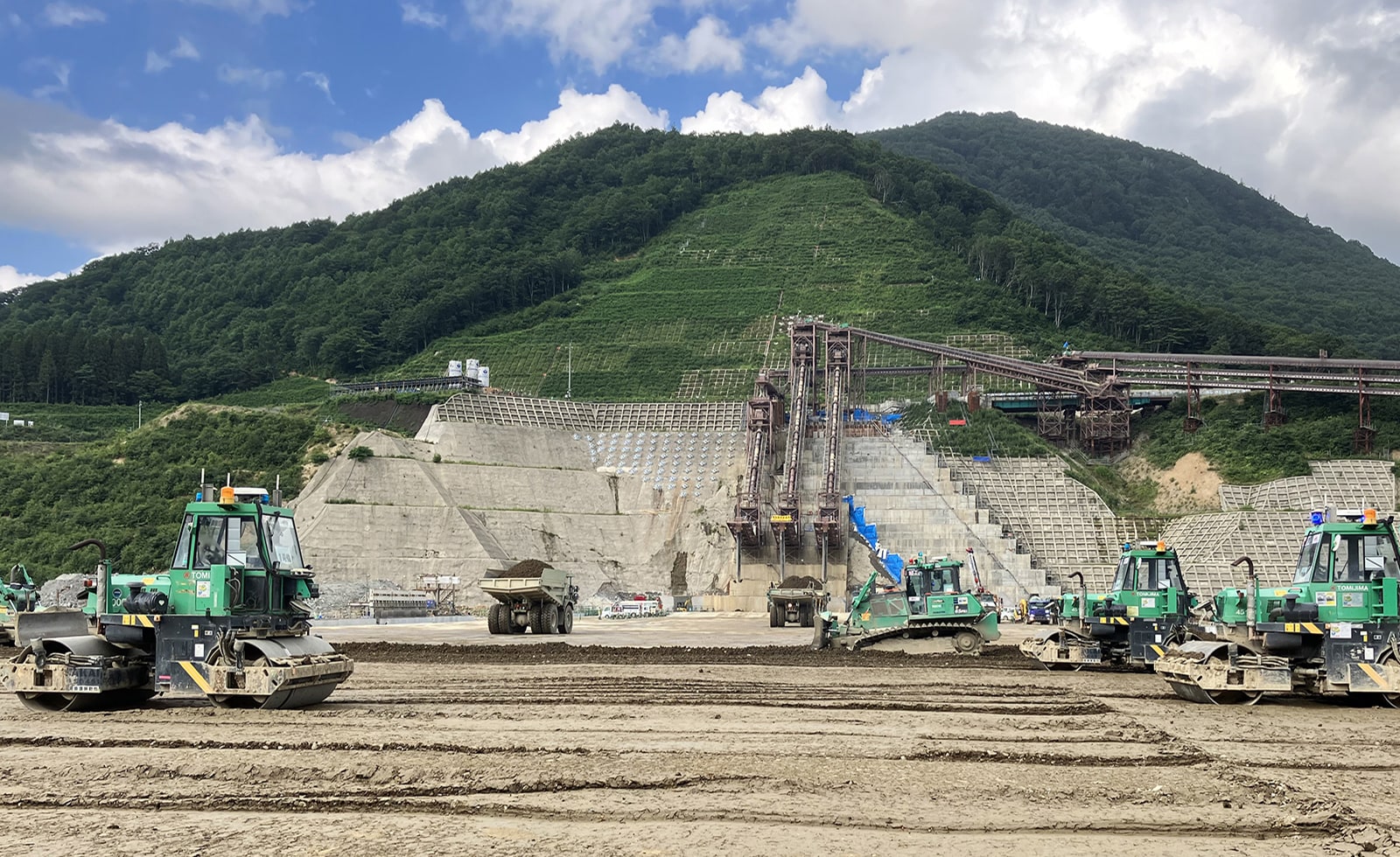 More than ten construction machines work together to place concrete at the embankment of Naruse スポーツベット ブックメーカー 口コミ