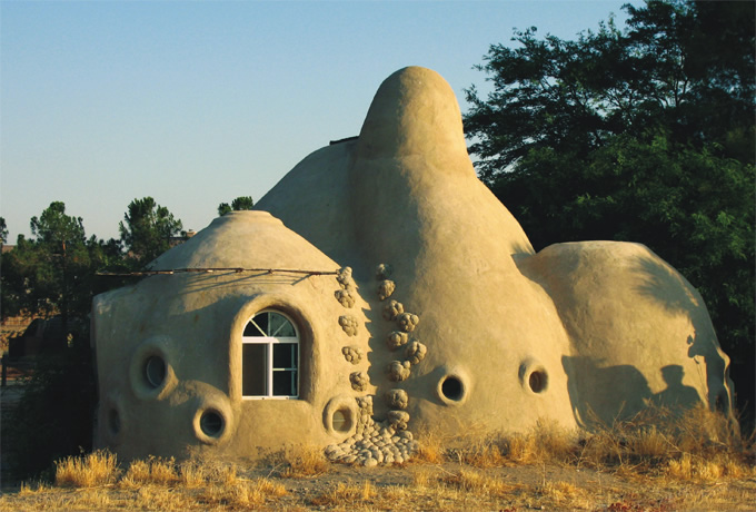 写真：外壁に現地の土を塗ると，大地から生えてきたような住居になる