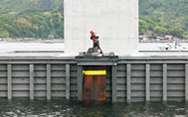 図版：スポーツベット 5チャンネル底版部のガイド内に，定着場所まで導く導杭を挿入する作業