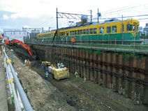 写真：営業線直近を掘削するため，ラディッシュアンカーで土留め