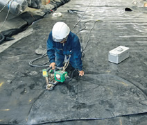 写真：遮水シートをつなぎ合わせる作業