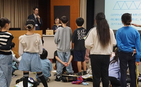 図版:スパゲッティで作った模型実験を見学する様子